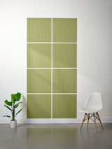 Four sage green tiles with vertical engraved parallel lines arranged in a 2x2 grid on a wall.