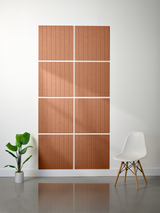 Eight terracotta tiles with parallel vertical engraved lines arranged in a 2x4 grid on white wall.