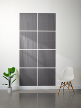 Gray engraved tiles with vertical line pattern arranged in offset grid layout on wall.