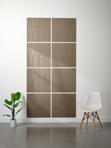 Four tan/beige tiles with vertical line engraving pattern arranged in 2x2 offset configuration on wall.
