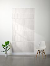 Light gray rectangular tiles with vertical line engraving arranged in offset pattern on wall.