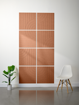 Eight terracotta tiles with engraved vertical lines and curved arc patterns arranged in a 2x4 grid on a wall.