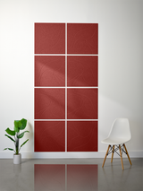 Eight red tiles with engraved topographic line patterns arranged in a 2x4 grid on a wall.