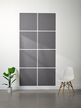 Gray tiles with engraved curved line patterns arranged in a 2x4 grid on a white wall.