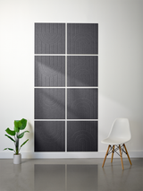 Four dark gray tiles with engraved geometric arch patterns arranged in a 2x2 grid on a white wall.