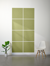 Eight sage green tiles with engraved arch and line patterns arranged in a 2x4 grid on a wall.