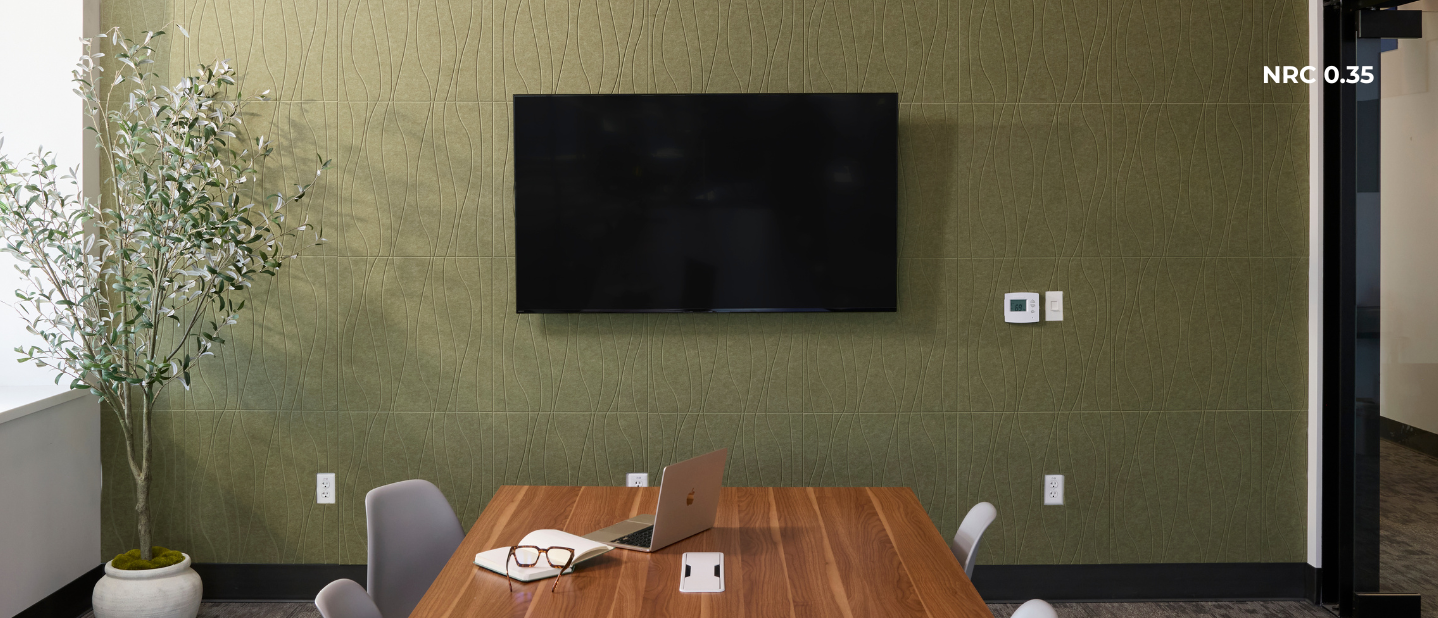 Modern office meeting room with a large TV on the wall, wooden table, and chairs.