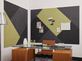 Modular wall panels in aloe green and charcoal black arranged in geometric diamond pattern above office desk.