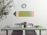 Colorful pencil-shaped wall art above a desk with stationery items.