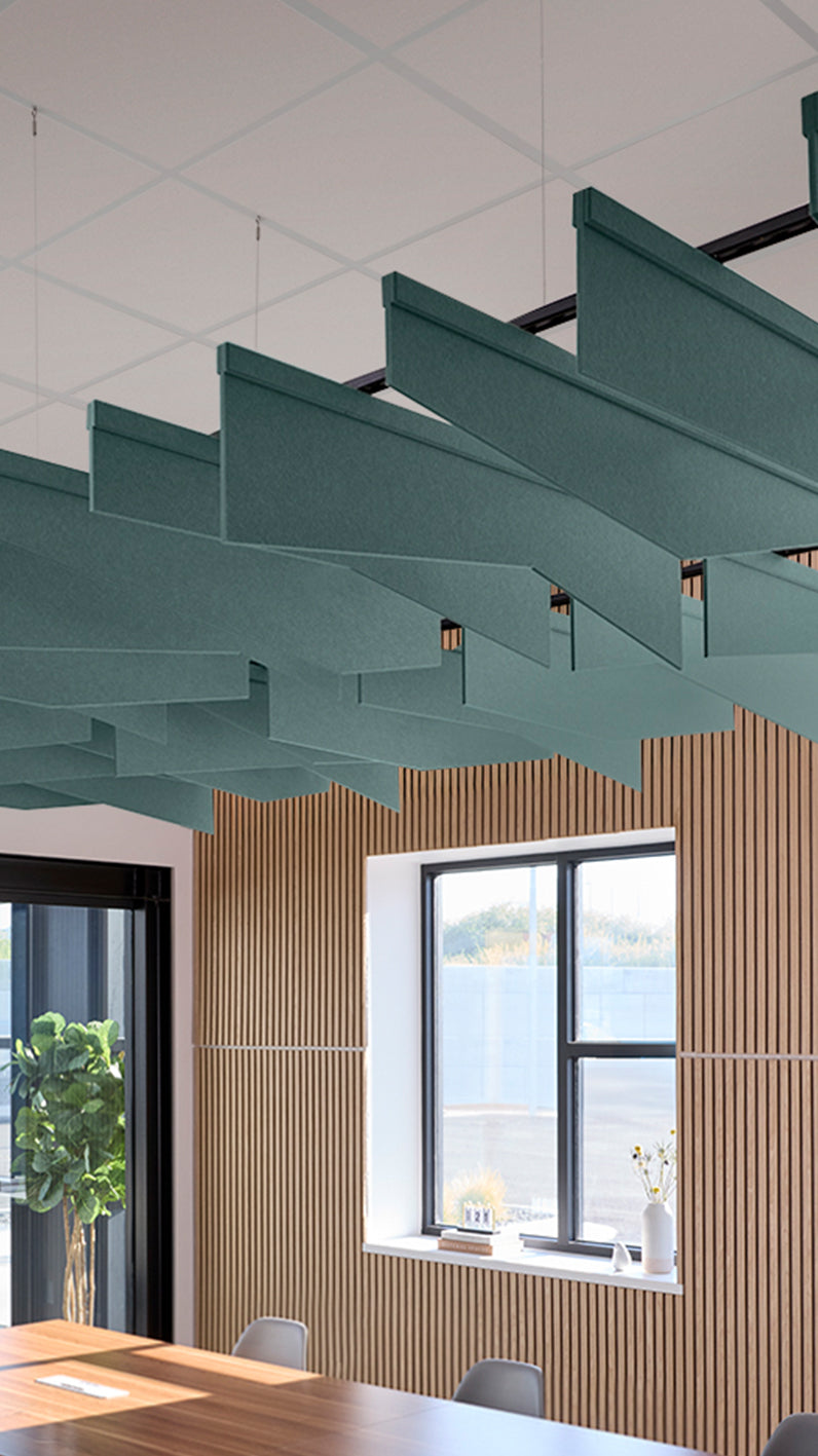 Blue green acoustic ceiling blade baffles suspended from the ceiling, installed in a conference room. Felt Right's acoustic blade baffles absorb 65% of sound waves, making office spaces quieter and feel more calm.
