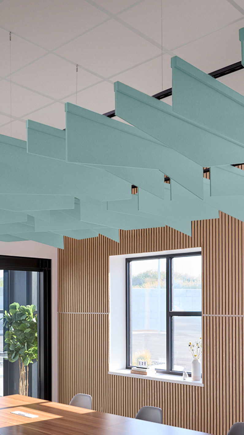 Baby blue acoustic ceiling blade baffles suspended from the ceiling, installed in a conference room. Felt Right's acoustic blade baffles absorb 65% of sound waves, making office spaces quieter and feel more calm.