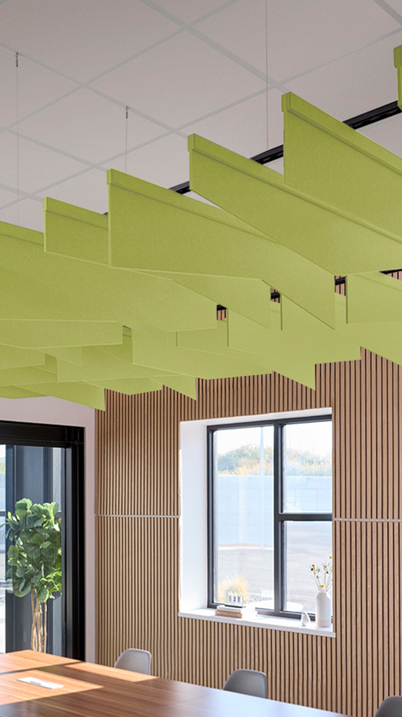 Lime green acoustic ceiling blade baffles suspended from the ceiling, installed in a conference room. Felt Right's acoustic blade baffles absorb 65% of sound waves, making office spaces quieter and feel more calm.