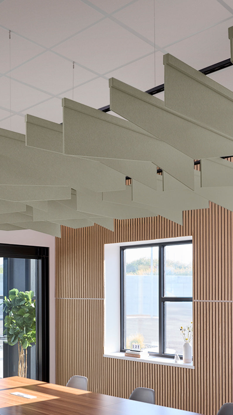 Soft green acoustic ceiling blade baffles suspended from the ceiling, installed in a conference room. Felt Right's acoustic blade baffles absorb 65% of sound waves, making office spaces quieter and feel more calm.