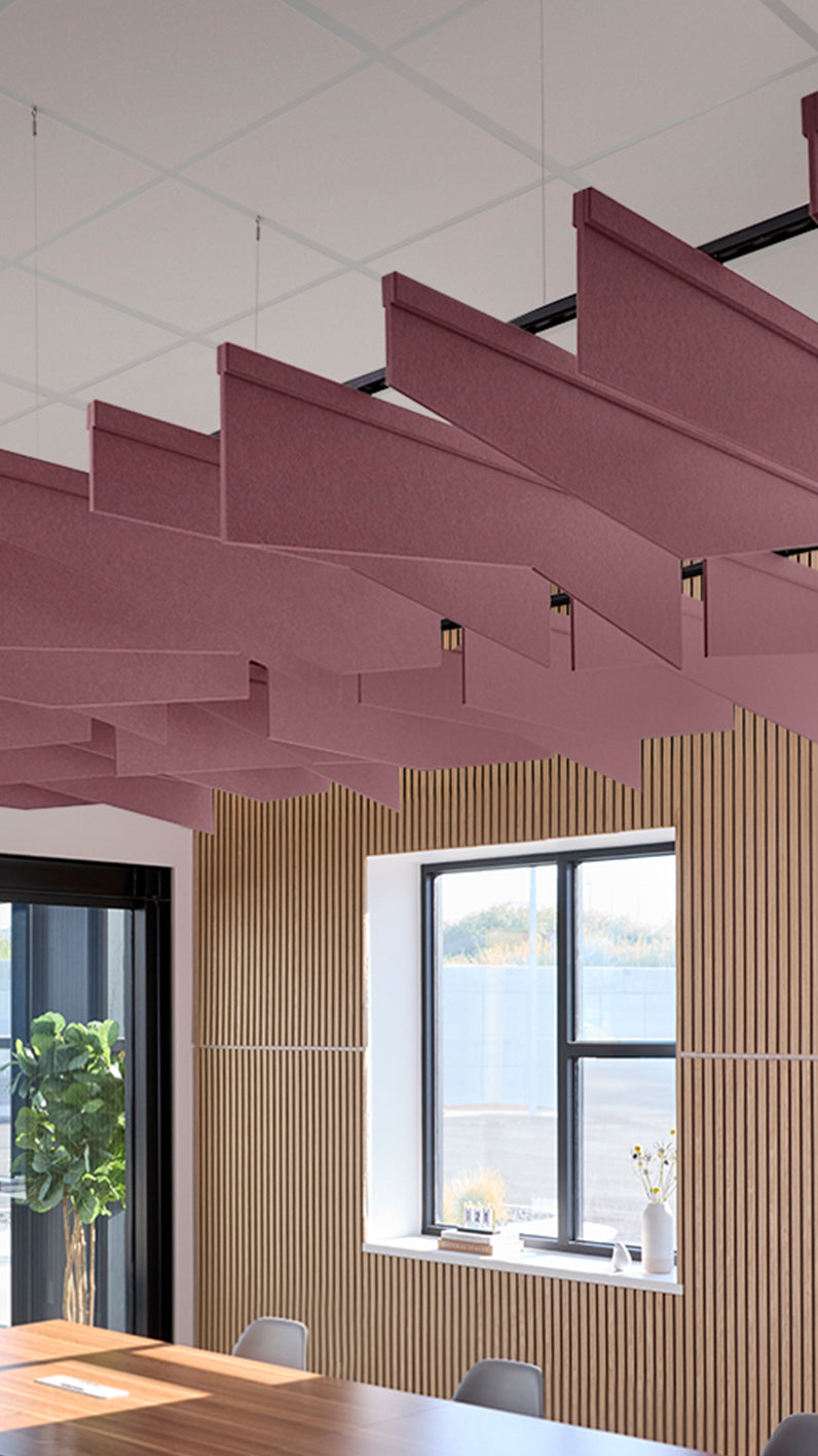 Deep reddish-purple acoustic ceiling blade baffles suspended from the ceiling, installed in a conference room. Felt Right's acoustic blade baffles absorb 65% of sound waves, making office spaces quieter and feel more calm.