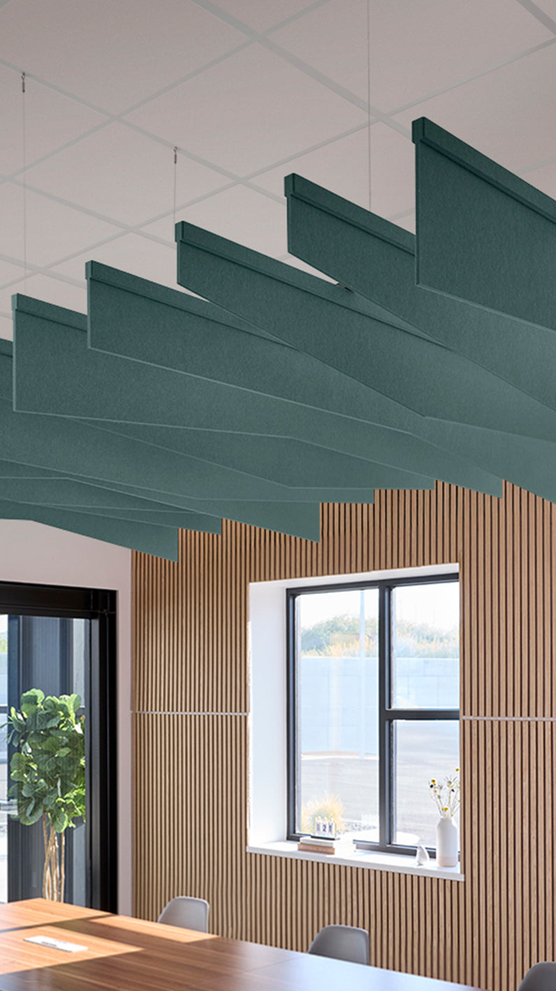 Blue-green acoustic ceiling blade baffles suspended from the ceiling, installed in a conference room. Felt Right's acoustic blade baffles absorb 65% of sound waves, making office spaces quieter and feel more calm.