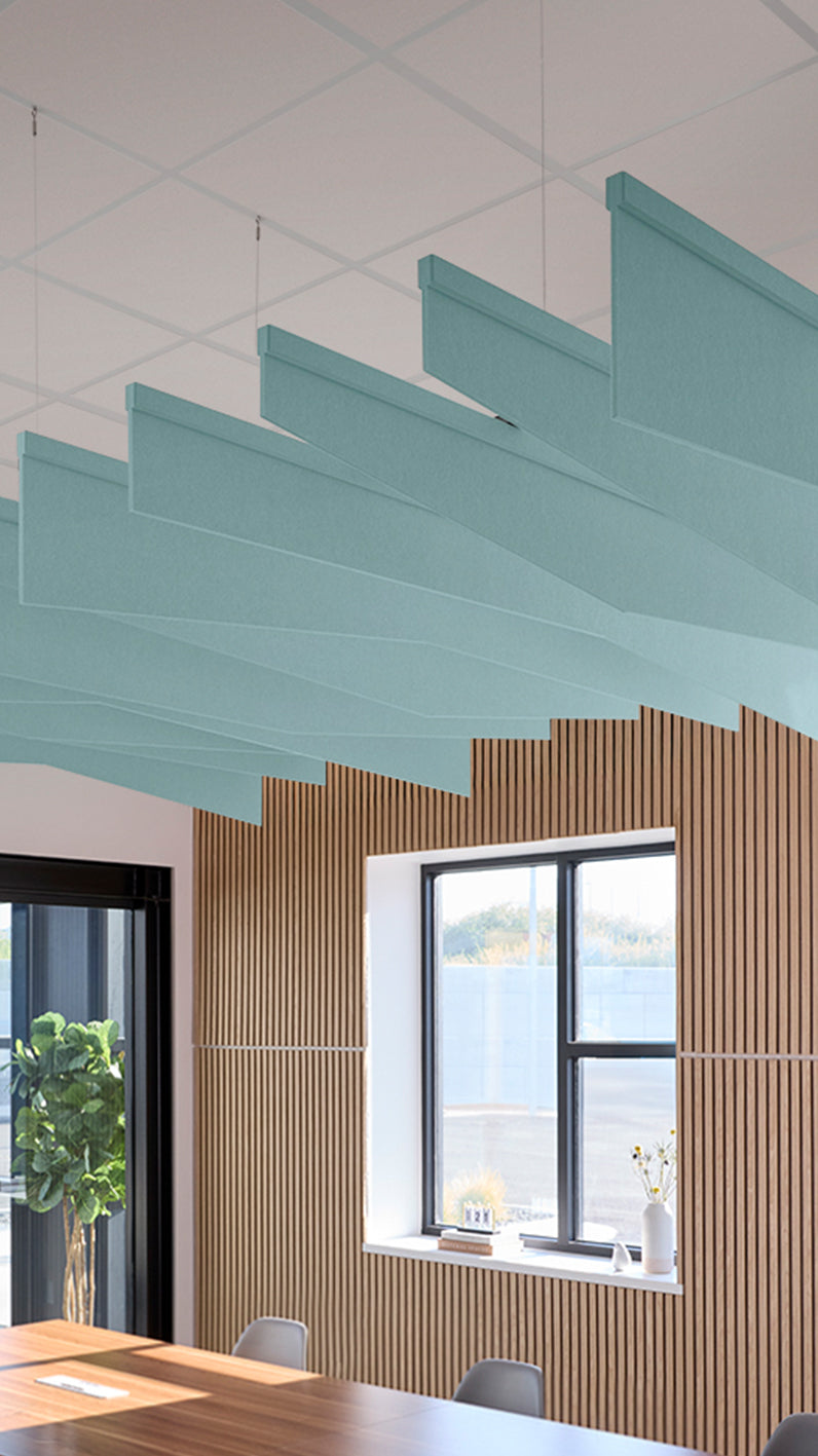 Baby blue acoustic ceiling blade baffles suspended from the ceiling, installed in a conference room. Felt Right's acoustic blade baffles absorb 65% of sound waves, making office spaces quieter and feel more calm.