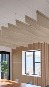 Creamy beige acoustic ceiling blade baffles suspended from the ceiling, installed in a conference room. Felt Right's acoustic blade baffles absorb 65% of sound waves, making office spaces quieter and feel more calm.