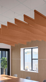 Dark orange acoustic ceiling blade baffles suspended from the ceiling, installed in a conference room. Felt Right's acoustic blade baffles absorb 65% of sound waves, making office spaces quieter and feel more calm.