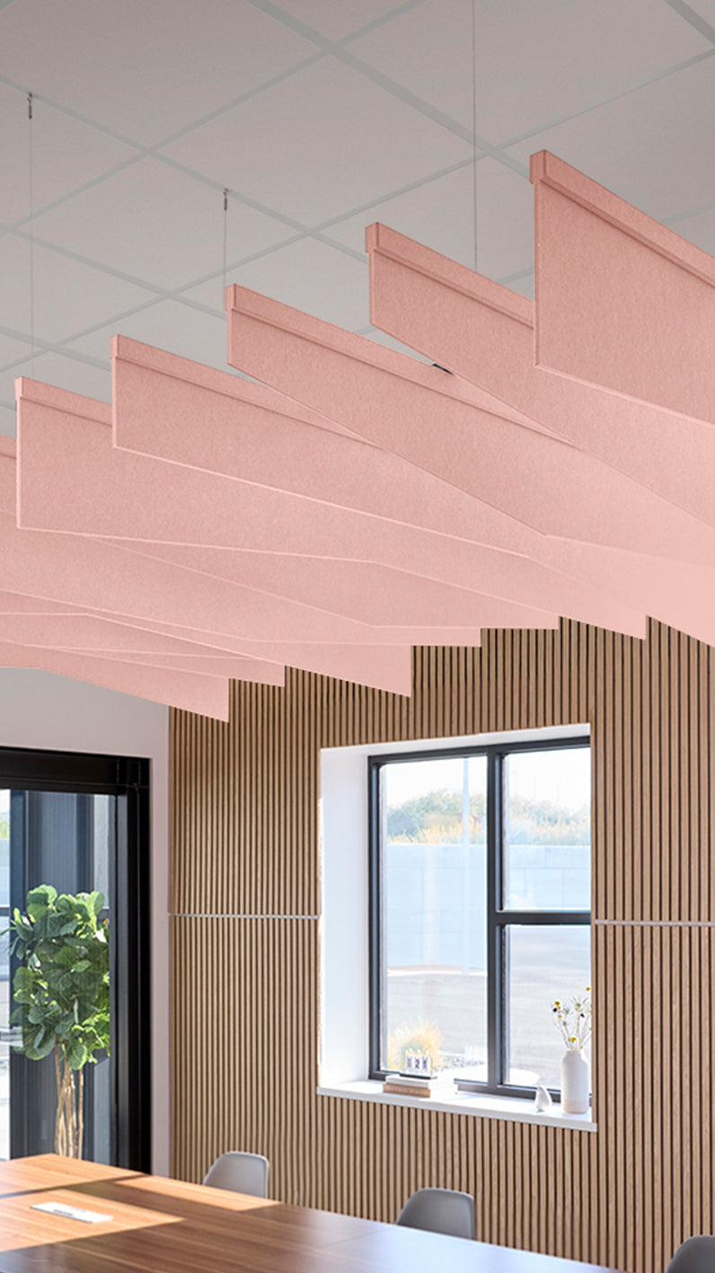 Soft pink acoustic ceiling blade baffles suspended from the ceiling, installed in a conference room. Felt Right's acoustic blade baffles absorb 65% of sound waves, making office spaces quieter and feel more calm.