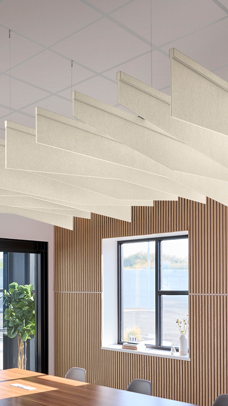 Cream acoustic ceiling blade baffles suspended from the ceiling, installed in a conference room. Felt Right's acoustic blade baffles absorb 65% of sound waves, making office spaces quieter and feel more calm.