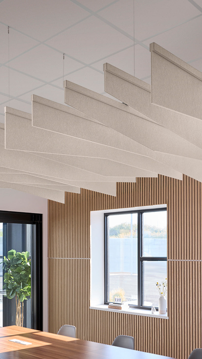 Light cream-brown acoustic ceiling blade baffles suspended from the ceiling, installed in a conference room. Felt Right's acoustic blade baffles absorb 65% of sound waves, making office spaces quieter and feel more calm.