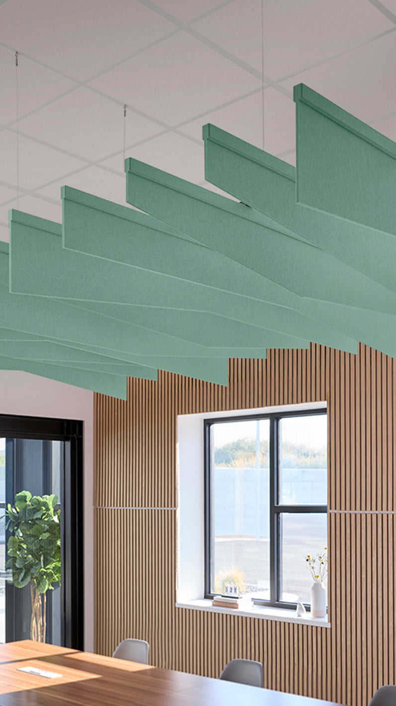 Mint green acoustic ceiling blade baffles suspended from the ceiling, installed in a conference room. Felt Right's acoustic blade baffles absorb 65% of sound waves, making office spaces quieter and feel more calm.