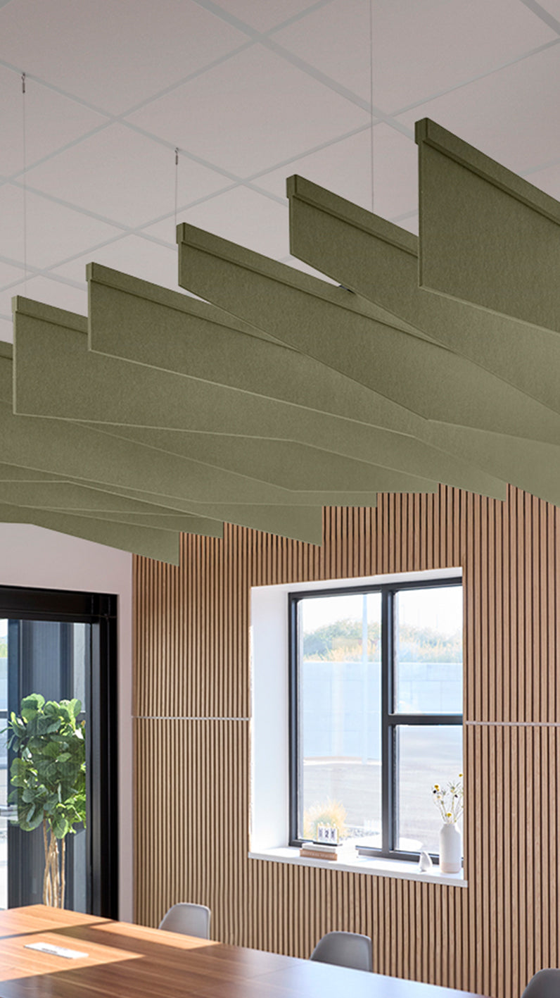 Green acoustic ceiling blade baffles suspended from the ceiling, installed in a conference room. Felt Right's acoustic blade baffles absorb 65% of sound waves, making office spaces quieter and feel more calm.