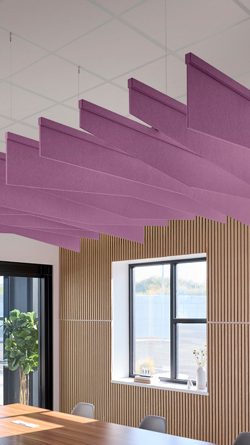Reddish-purple acoustic ceiling blade baffles suspended from the ceiling, installed in a conference room. Felt Right's acoustic blade baffles absorb 65% of sound waves, making office spaces quieter and feel more calm.