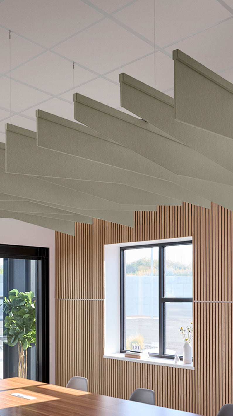 Soft green acoustic ceiling blade baffles suspended from the ceiling, installed in a conference room. Felt Right's acoustic blade baffles absorb 65% of sound waves, making office spaces quieter and feel more calm.