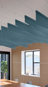 Teal blue acoustic ceiling blade baffles suspended from the ceiling, installed in a conference room. Felt Right's acoustic blade baffles absorb 65% of sound waves, making office spaces quieter and feel more calm.