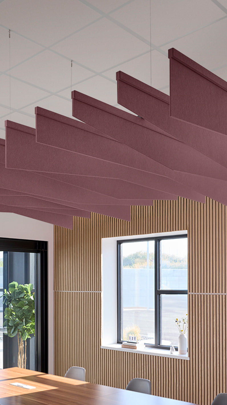 Deep reddish-purple acoustic ceiling blade baffles suspended from the ceiling, installed in a conference room. Felt Right's acoustic blade baffles absorb 65% of sound waves, making office spaces quieter and feel more calm.