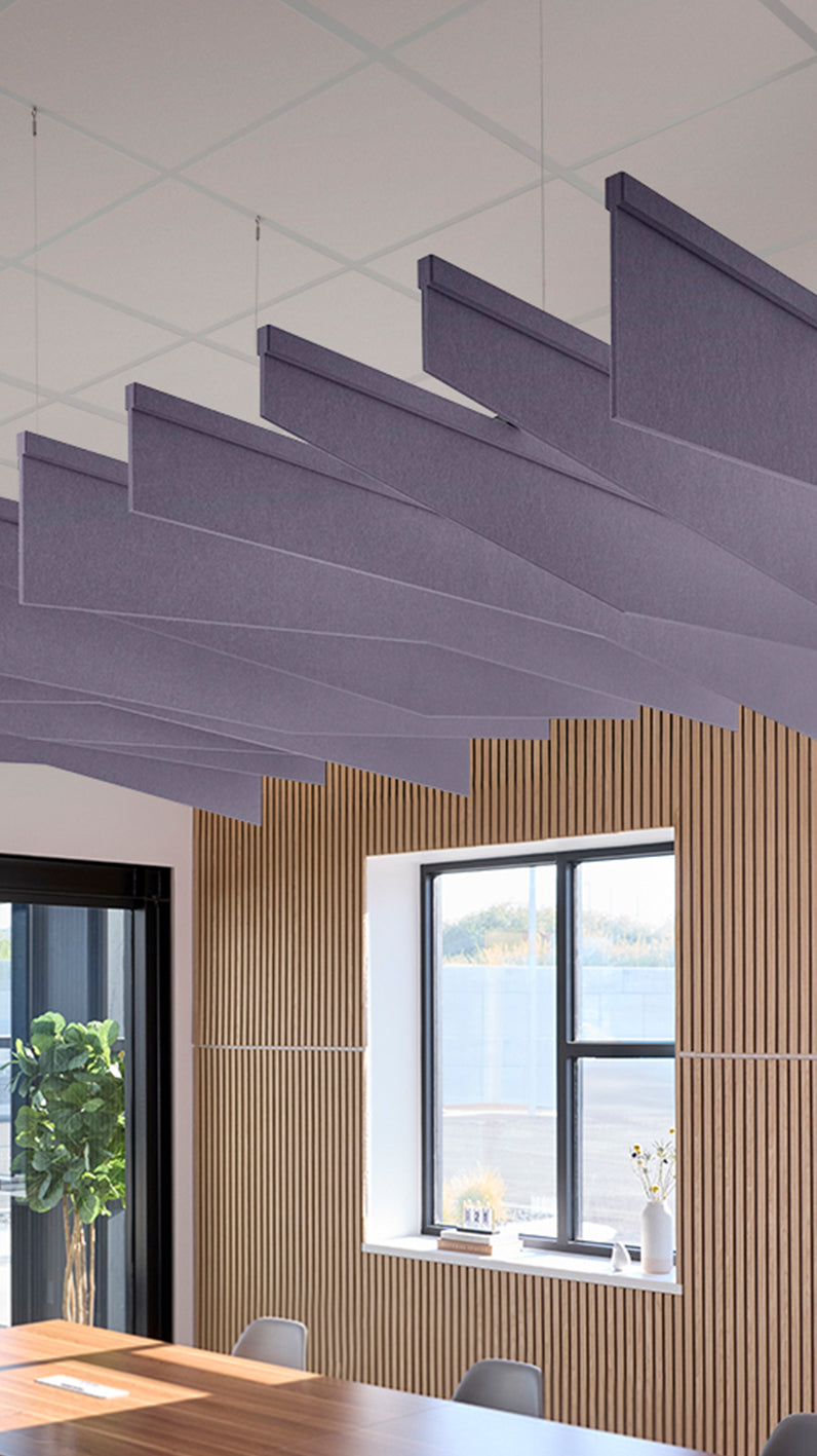Soft violet acoustic ceiling blade baffles suspended from the ceiling, installed in a conference room. Felt Right's acoustic blade baffles absorb 65% of sound waves, making office spaces quieter and feel more calm.