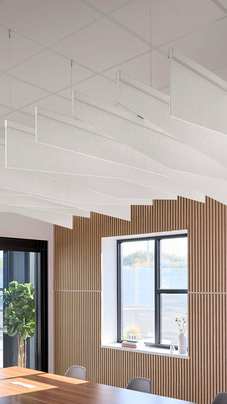 White acoustic ceiling blade baffles suspended from the ceiling, installed in a conference room. Felt Right's acoustic blade baffles absorb 65% of sound waves, making office spaces quieter and feel more calm.