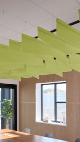 Lime-green angled acoustic baffles suspended from ceiling in modern office space with wood paneling and windows.