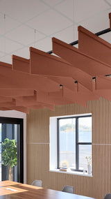 Rust-colored angled acoustic baffles suspended from ceiling in modern office space above wooden slat wall paneling.