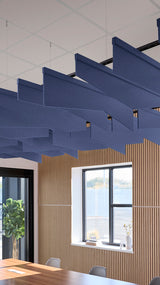 Navy blue angled acoustic baffles suspended from ceiling in modern office space with wood paneling and windows.