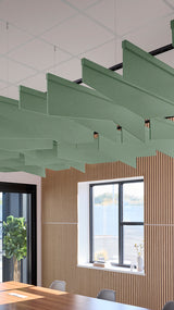 Green angled acoustic baffles suspended from ceiling in office space with wood wall paneling and windows.