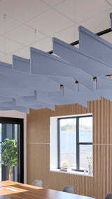 Blue angled acoustic baffles suspended from ceiling in modern office space with wood paneling and windows.