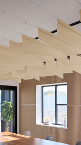 Angled acoustic baffles in beige suspended from ceiling with black mounting hardware in modern office space.