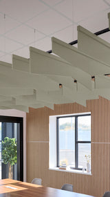 Angled acoustic baffles in sage green suspended from ceiling in modern office space with wood slat wall paneling.