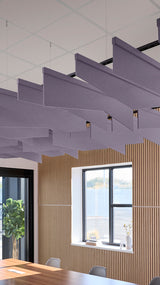 Multiple angled purple acoustic baffles suspended from ceiling in modern office space with wood-paneled walls.