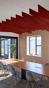 Red angled acoustic baffles suspended from ceiling in modern conference room above wooden table and chairs.