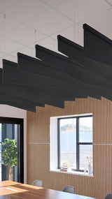 Black angled acoustic baffles suspended from ceiling in modern office space with wood paneling and windows.