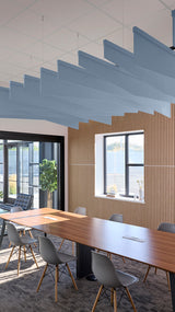 Blue angled acoustic baffles suspended from ceiling above conference room with wooden wall paneling.