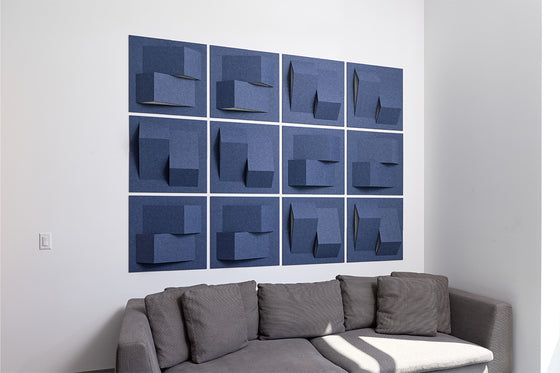 Gray sectional sofa in a room with blue abstract acoustic wall art