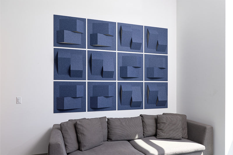 Gray sectional sofa in a room with blue abstract acoustic wall art