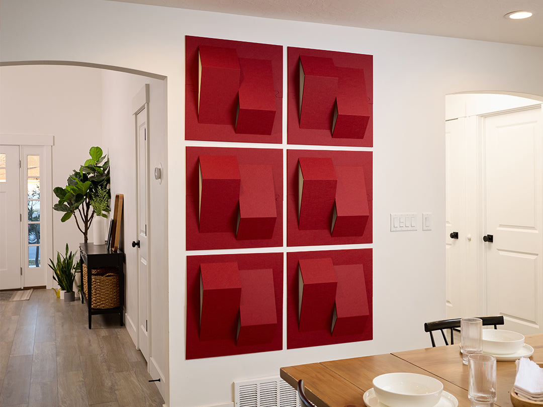 Red wall art acoustic panels in a modern interior setting with a dining table and chairs.