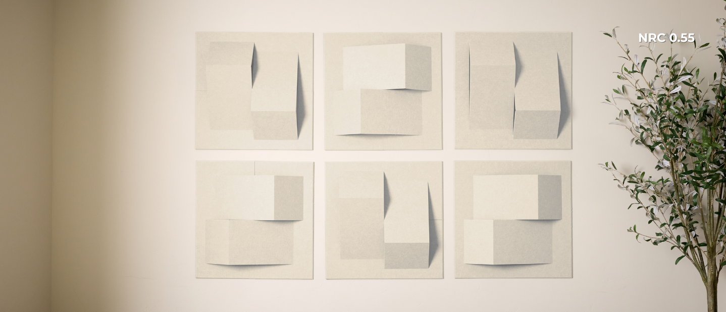 Set of abstract art pieces on a wall with a plant to the right.