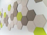 A Felt Right Wall Design on a wall-mounted hexagonal tile artwork in a room featuring shades of green and gray.
