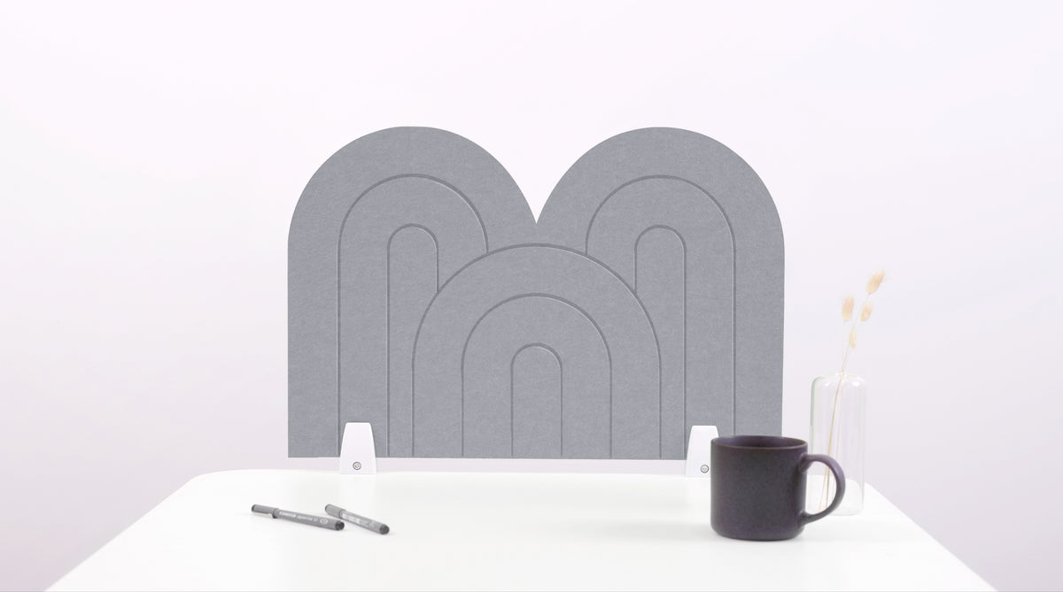A light gray arch-shaped desk divider on a white desk. For the side of your desk.